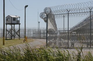 FILE - This July 10, 2017, file photo shows a tower outside of the razor wire at the Great Plains Correctional Facility in Hinton, Okla. Prisons in Oklahoma are locked down after several inmate fights over the weekend caused one inmate death and more than a dozen injuries. (AP Photo/Sue Ogrocki, File)