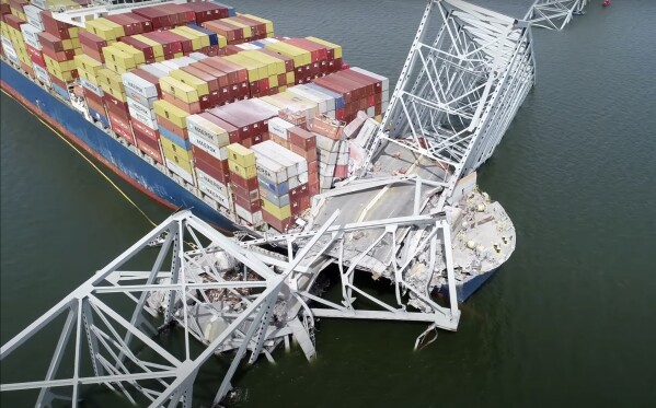 FILE - In this image from video released by the National Transportation and Safety Board, the container ship Dali is stuck under part of the structure of the Francis Scott Key Bridge after the ship hit the bridge, Tuesday, March 26, 2024, in Baltimore. (NTSB via AP, File)