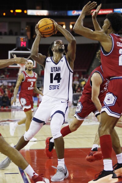 Josh Uduje, de Utah State, se enfrenta con fuerza a Leo Colimerio, de Fresno State, durante la primera mitad de un partido de baloncesto universitario de la NCAA en Fresno, California, el martes 27 de febrero de 2024. (Foto AP/Gary Kazanjian)