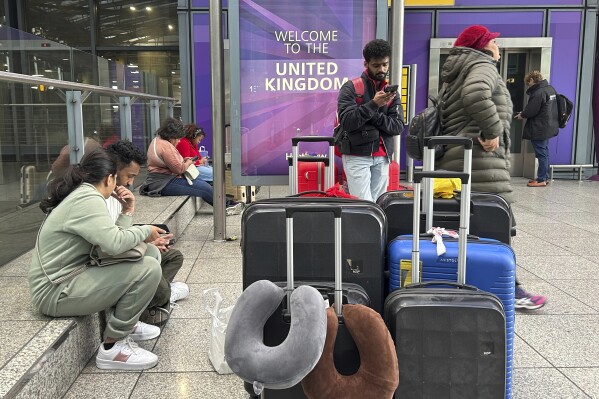 Travellers are waiting as Britain's Heathrow Airport has closed for the full day Friday after an electrical substation fire knocked out its power, disrupting flights for hundreds of thousands of passengers at one of Europe's biggest travel hubs in London, Friday, March 21, 2025.(AP Photo/Kin Cheung)