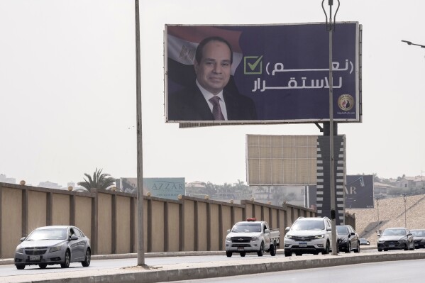 Vehicles pass under a billboard supporting Egyptian President Abdel Fattah el-Sissi for the coming presidential elections, erected by Egypt's political party of Homat Watan, the Protectors of the Nation, in Cairo, Egypt, Monday, Sept. 4, 2023. Arabic reads, 