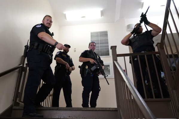 U.S. Capitol Police officers clear a stairwell in the Dirksen Senate Office Building next to the Russell Senate Office Building, Wednesday, Aug. 2, 2023, on Capitol Hill in Washington. (AP Photo/J. Scott Applewhite)