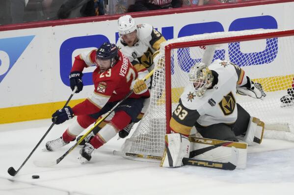 Vegas Golden Knights center Jack Eichel (9) defends Florida Panthers center Carter Verhaeghe (23), as goaltender Adin Hill (33) protects the net during the first period of Game 3 of the NHL hockey Stanley Cup Finals, Thursday, June 8, 2023, in Sunrise, Fla. (AP Photo/Rebecca Blackwell)