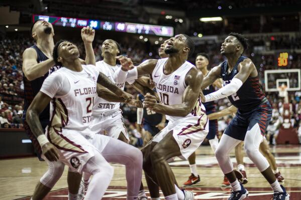 Florida State guard Cam'Ron Fletcher (21), guard Caleb Mills (4) and forward Malik Osborne (10) box out Pennsylvania for a rebound in the first half of an NCAA college basketball game in Tallahassee, Fla., Wednesday, Nov. 10, 2021. (AP Photo/Mark Wallheiser)