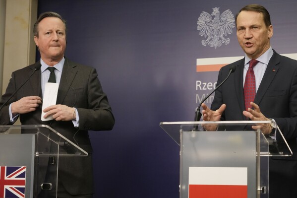 British Foreign Secretary David Cameron, left, and his Polish host, Foreign Minister Radek Sikorski tell reporters they are appealing to the U.S. Congress to approve aid package for Ukraine, which for two years has been fighting Russia's military aggression, as an element needed for the preservation of peace in Europe, in Warsaw, Poland, on Thursday, Feb.15, 2024. (AP Photo/Czarek Sokolowski)