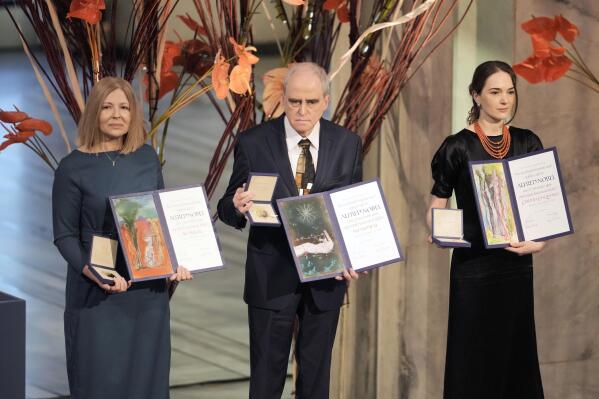 Representatives of the 2022 Nobel Peace Prize laureates, from left: Natalia Pinchuk, the wife of Nobel Peace Prize winner Ales Bialiatski, Yan Rachinsky, chairman of the International Memorial Board and Oleksandra Matviychuk, head of the Ukraine's Center for Civil Liberties pose with awards during the Nobel Peace Prize ceremony at Oslo City Hall, Norway, Saturday, Dec. 10, 2022. This year's Nobel Peace Prize was shared by jailed Belarus rights activist Ales Bialiatski, the Russian group Memorial and the Center for Civil Liberties in Ukraine. The Norwegian Nobel Committee said the laureates "have made an outstanding effort to document war crimes, human right abuses and the abuse of power. Together they demonstrate the significance of civil society for peace and democracy." (AP Photo/ Markus Schreiber)
