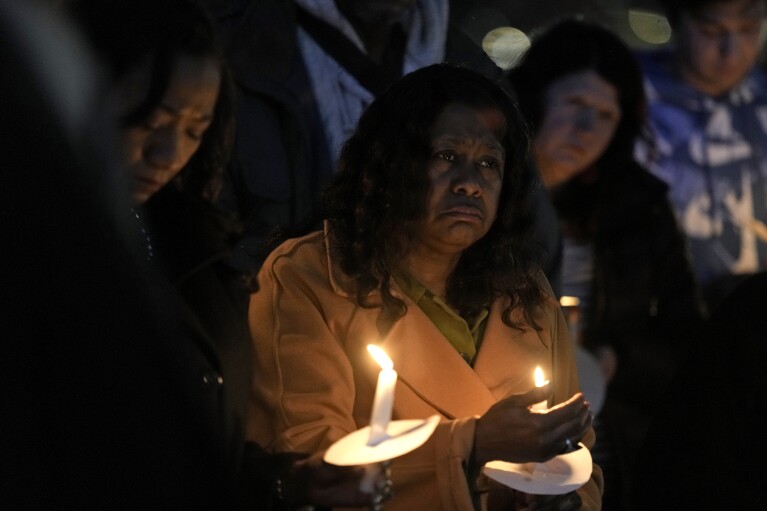 People on Thursday, February 15, 2024 in Kansas City, MO.  Attended a candlelight vigil for the victims of the shooting at the Kansas City Chiefs Super Bowl victory rally in.  More than 20 people were injured and a woman died in the shooting late Wednesday.  The rally was held at nearby Union Station.  (AP Photo/Charlie Riedel)