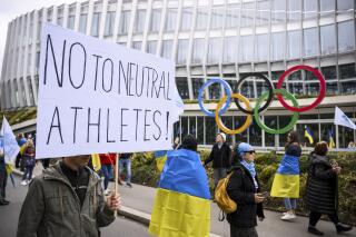 Members of the Geneva branch of Ukrainian society in Switzerland protest during a rally to urge International Olympic Committee to reconsider their decision of participation of Russian and Belarusian athletes under white neutral flag at the next 2024 Paris Olympic Games, in front of the IOC headquarters, in Lausanne, Switzerland, Saturday, March 25, 2023. (Jean-Christophe Bott/Keystone via AP)