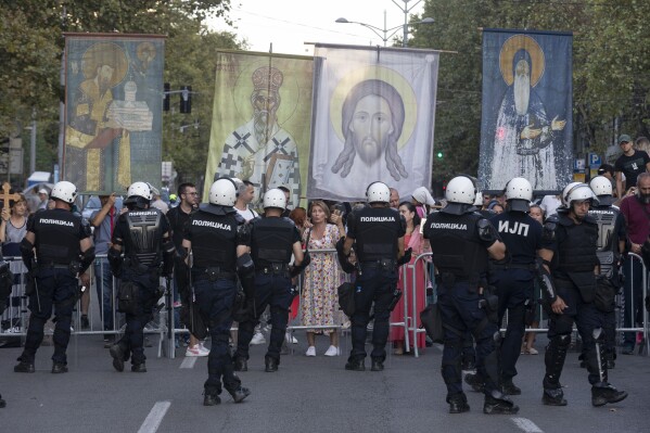 Anti-gay protesters hold religious banners amid heavy police presence and during a Pride march in Belgrade, Serbia, Saturday, Sept. 9, 2023. Hundreds of Pride activists gathered in the Serbian capital Saturday amid heavy police presence and anti-gay messages sent by the country's conservative leadership and far rights groups. (AP Photo/Marko Drobnjakovic)