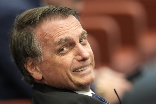 Brazil's former President Jair Bolsonaro talks with his lawyer during his Supreme Court trial as he and others face charges for an alleged coup plot to keep him in office after his 2022 election defeat, in Brasilia, Brazil, Tuesday, June 10, 2025. (AP Photo/Eraldo Peres)