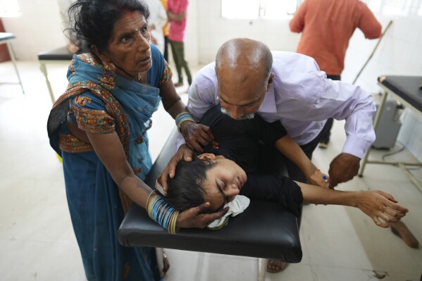 ARCHIVO - Un padre intenta consolar a su hija que sufre una enfermedad relacionada con el calor mientras la llevan al hospital del distrito gubernamental en Ballia, estado de Uttar Pradesh, India, el 19 de junio de 2023. Últimos cálculos de varias agencias científicas, viernes 12 de enero de 2023 Y todo dice temperaturas medias El año 2023 batió los récords actuales de temperatura global.  (Foto AP/Rajesh Kumar Singh, archivo)