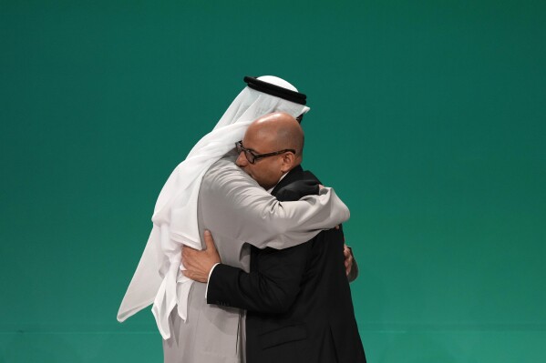 United Nations Climate Chief Simon Stiell, right, and COP28 President Sultan al-Jaber embrace at the COP28 U.N. Climate Summit, Wednesday, Dec. 13, 2023, in Dubai, United Arab Emirates. (AP Photo/Kamran Jebreili)