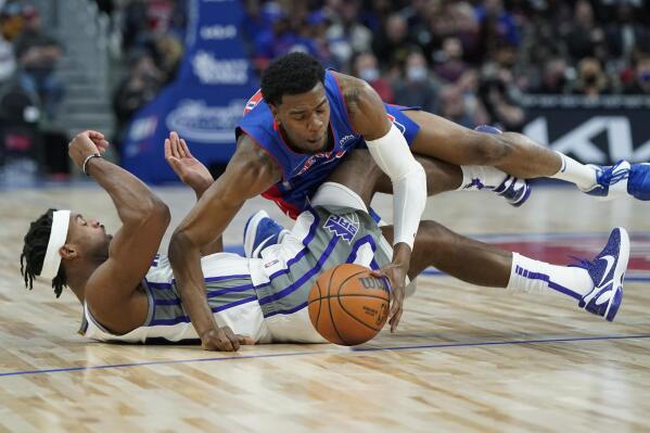 Detroit Pistons guard Josh Jackson (20) falls on Sacramento Kings guard Buddy Hield (24) as they chase the loose ball during the first half of an NBA basketball game, Monday, Nov. 15, 2021, in Detroit. (AP Photo/Carlos Osorio)
