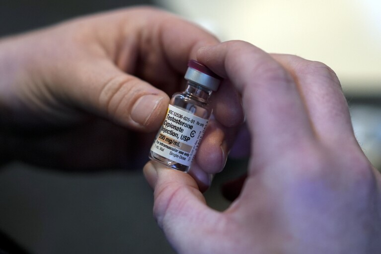 Ashton Colby holds a vial of Testosterone Cypionate Injection in his apartment bathroom in Columbus, Ohio, on Thursday, Jan. 18, 2024. (AP Photo/Carolyn Kaster)