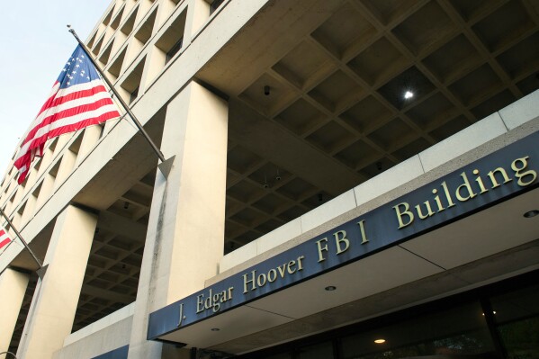 FILE - On Nov. 2, 2016, the FBI's J.  Edgar Hoover Headquarters Building.  Police say two men carjacked an FBI agent in Washington, DC, amid a sharp increase in the number of carjackings in the nation's capital.  According to the police, the theft took place on Wednesday at noon.  The FBI says it is under investigation by the bureau's Washington field office and the Metropolitan Police Department.  (AP Photo/Cliff Owen, File)
