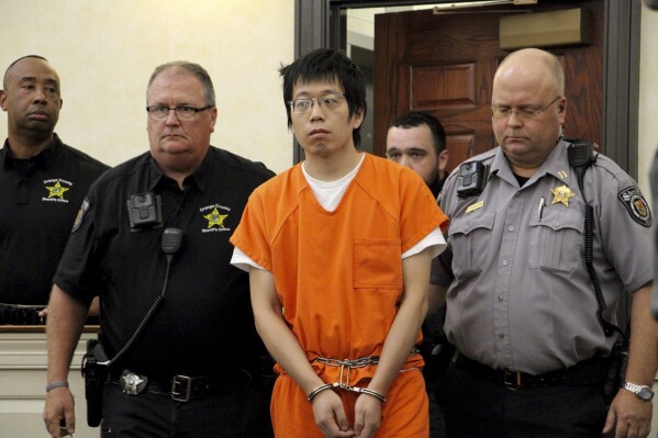 Tailei Qi, the graduate student suspected in the fatal shooting of a University of North Carolina at Chapel Hill faculty member, center, makes his first appearance at the Orange County Courthouse in Hillsborough, N.C., Tuesday, Aug. 29, 2023. Qi has been charged by the UNC Police Department with first-degree murder and possession of a weapon on educational property, both felony charges. (AP Photo/Hannah Schoenbaum)