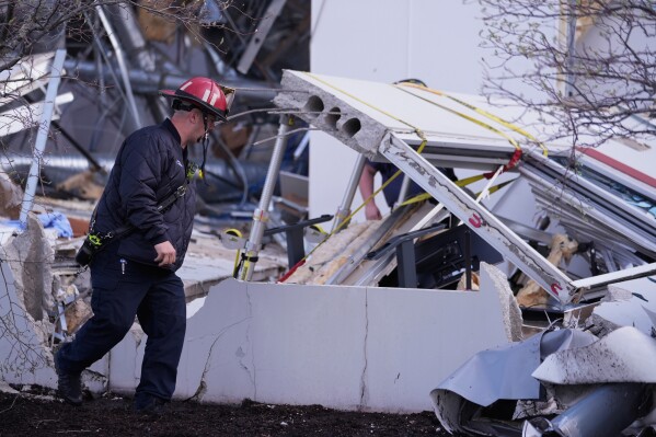 Brownsburg firefighters survey storm damage to a warehouse in Brownsburg, Ind., Thursday, April 3, 2025. (AP Photo/Michael Conroy)