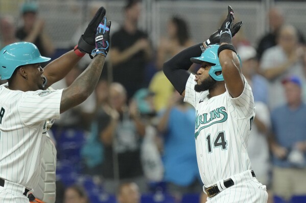 Miami Marlins' Bryan De La Cruz (14) celebrates his two-run home run with Jorge Soler during the first inning of a baseball game, Friday, July 28, 2023, in Miami. (AP Photo/Marta Lavandier)