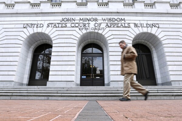FILE - A man walks in front of the 5th U.S. Circuit Court of Appeals, Jan. 7, 2015, in New Orleans. The federal appeals court has temporarily delayed Mississippi officials from creating a state-run court in part of the majority-Black capital city of Jackson, Miss., even though a federal district court judge dismissed requests to block the new court in a ruling filed late Sunday, Dec. 31, 2023. (AP Photo/Jonathan Bachman, File)