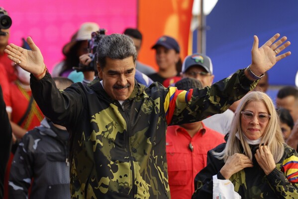 FILE - President Nicolas Maduro, accompanied by first lady Cilia Flores, greets supporters during an event marking the anniversary of a 1958 coup ousting dictator Marcos Pérez Jiménez, in Caracas, Venezuela, Jan. 23, 2024. (AP Photo/Jesus Vargas, File)