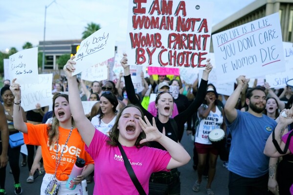 FILE - Protesters in Phoenix shout as they join thousands marching around the Arizona state Capitol after the U.S. Supreme Court decision to overturn the landmark Roe v. Wade abortion decision on June 24, 2022. Three state supreme courts are scheduled to hear arguments in abortion-related cases this week. (AP Photo/Ross D. Franklin, File)