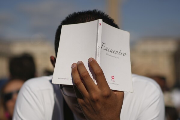 A man prays during the conclave to elect a new pope, in St. Peter's Square at the Vatican, Thursday, May 8, 2025. (AP Photo/Andrew Medichini)