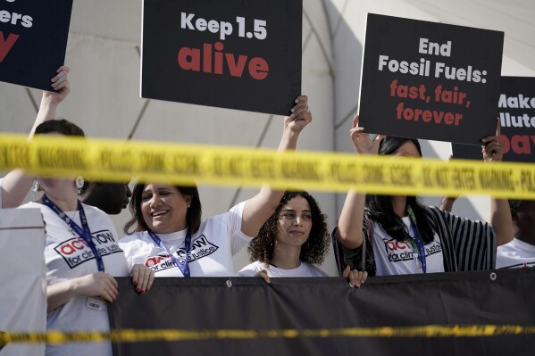 FILE - Activists protest against fossil fuels at the COP28 U.N. Climate Summit, Dec. 5, 2023, in Dubai, United Arab Emirates. Earth last year shattered global annual heat records, the European climate agency said Tuesday, Jan. 9, 2024. (AP Photo/Joshua A. Bickel, File)