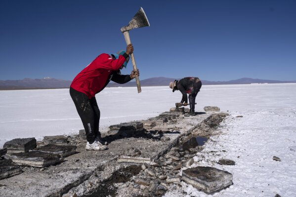 Workers harvest salt in the Salinas Grandes salt flats in Jujuy, Argentina, Tuesday, April 25, 2023. The salt flat brings income to towns through tourism and small-scale salt harvesting. (AP Photo/Rodrigo Abd)