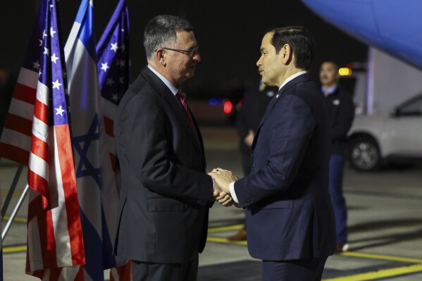 Israel's Foreign Minister Gideon Sa'ar shakes hands with U.S. Secretary of State Marco Rubio as he arrives in Israel, on the first leg of his Middle East trip, in Tel Aviv, Israel, Saturday, Feb. 15, 2025. (Evelyn Hockstein/Pool Photo via AP)