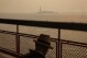 FILE - The Statue of Liberty, covered in a haze-filled sky, is photographed from the Staten Island Ferry, June 7, 2023, in New York. The smoke from Canadian wildfires that drifted into the U.S. led to a spike in people with asthma visiting emergency rooms — particularly in the New York area. The U.S. Centers for Disease Control and Prevention published two studies Thursday, Aug. 24 about the health impacts of the smoke, which shrouded city skylines with an orange haze in late spring, and a medical journal also released a study this week. (AP Photo/Yuki Iwamura, File)