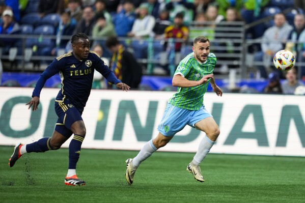 Seattle Sounders forward Jordan Morris, right, and Vancouver Whitecaps defender Javain Brown pursue the ball during the first half of an MLS soccer match Saturday, May 18, 2024, in Seattle. (AP Photo/Lindsey Wasson)