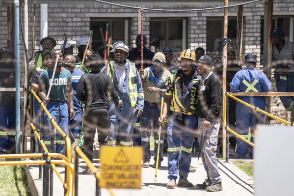 FILE - Mineworkers at the entrance of a goldmine in Springs, near Johannesburg, South Africa, Wednesday, Oct. 25, 2023. More than 2,000 workers have remained underground Tuesday, Dec. 19 in two shafts at Implats’ Bafokeng Rasimone Platinum Mine in the North West province of South Africa for a second day in a protest over pay and benefits. There were two recent underground protests at a gold mine in the city of Springs, near Johannesburg, one in October and one earlier this month. On both occasions, hundreds of mineworkers remained underground for days amid allegations some were holding others hostage in a dispute over which union should represent them. (AP Photo, file)