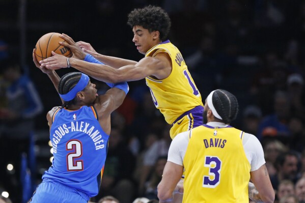 Oklahoma City Thunder guard Shai Gilgeous-Alexander (2) tries to score against Los Angeles Lakers guard Max Christie, middle, as Los Angeles Lakers forward Anthony Davis (3) looks on during the first half of an NBA basketball game, Thursday, Nov. 30, 2023, in Oklahoma City. (AP Photo/Nate Billings)