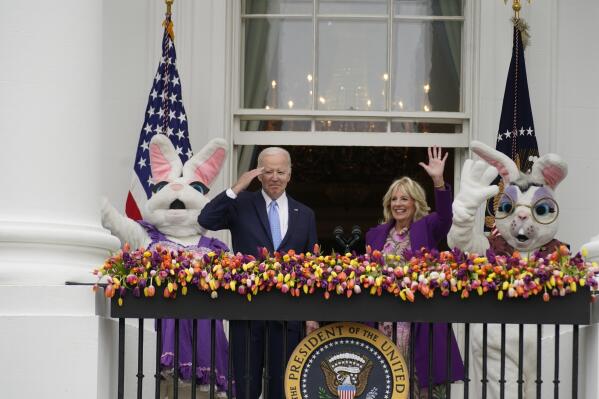 President Joe Biden appears and salutes with first lady Jill Biden and the Easter Bunnies on the Blue Room balcony at the White House during the White House Easter Egg Roll, Monday, April 18, 2022, in Washington. (AP Photo/Andrew Harnik)