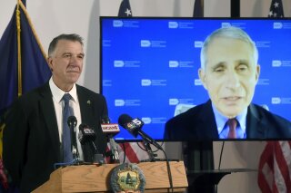 Vermont's Gov. Phil Scott, left, listens as Dr. Anthony Fauci, director of the National Institute of Allergy and Infectious Diseases, discusses Vermont's response to the COVID-19 pandemic during a press conference Tuesday, Sept. 15, 2020, in Montpelier, Vt. (Jeb Wallace-Brodeur/The Times Argus via AP)