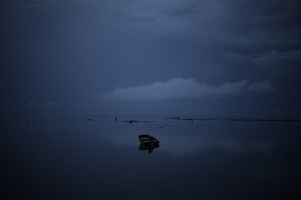 Boats parked in the lagoon at sunrise on Thursday, January 11, 2024, in Te Aupoo, Tahiti, French Polynesia.  (AP Photo/Daniel Cole)