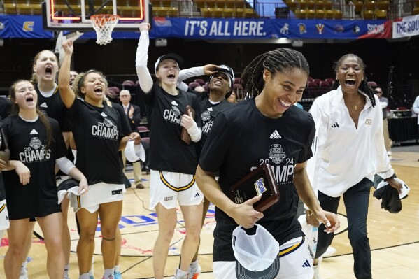 Chattanooga guard Jada Guinn is cheered by teammates as she is awarded the Most Valuable Player award for NCAA women's college basketball championship game for the Southern Conference tournament, Sunday, March 10, 2024, in Asheville, N.C. Chattanooga won 69-60 over UNC Greensboro. (AP Photo/Kathy Kmonicek)