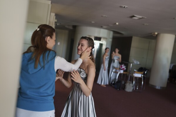 Choreographer Artemis Ignatiou, left, embraces a performer, who will take part in the flame lighting ceremony for the Paris Olympics, at the Olympic Velodrome in Athens, Greece, Saturday, March 30, 2024. Every two years, a countdown to the Olympic games is launched from its ancient birthplace with a flame lighting ceremony in southern Greece at Ancient Olympia. The event is marked with a performance by dancers who assume the role of priestesses and male companions, their movement inspired by scenes on millennia-old artwork. (AP Photo/Petros Giannakouris)