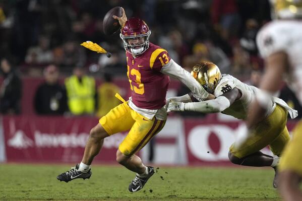 Southern California quarterback Caleb Williams, left, escapes a tackle by Notre Dame defensive lineman Justin Ademilola as a flag is thrown on the play during the second half of an NCAA college football game Saturday, Nov. 26, 2022, in Los Angeles. (AP Photo/Mark J. Terrill)
