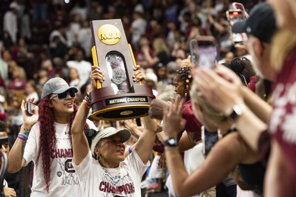 South Carolina basketball coach Dawn Staley carries the NCAA college women's basketball championship trophy around Colonial Life Arena, in Columbia, S.C., Monday, April 8, 2024. South Carolina defeated Iowa to win the national title. (Joshua Boucher/The State via AP)