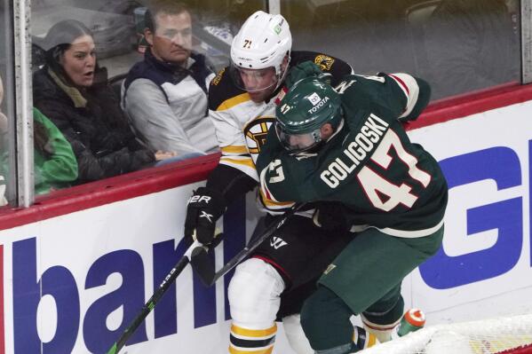 Minnesota Wild's Alex Goligoski (47) and Boston Bruins' Taylor Hall (71) chase the puck during the first period of an NHL hockey game Wednesday, March 16, 2022, in St. Paul, Minn. (AP Photo/Jim Mone)