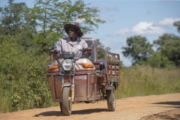 Josephine Nyevhe, a volunteer village health worker, conducts weekly visits on her electric tricycle in Hwedza Zimbabwe, Thursday, March 6 2025. (AP Photo/Aaron Ufumeli)