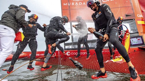 In this photo provided by SailGP, Team Spain SailGP pilot Diego Botin sprays Barons de Rothschild champagne on his teammates as they celebrate winning the Oracle Los Angeles Sail Grand Prix at the Port of Los Angeles, Sunday, July 23, 2023. (Ricardo Pinto/SailGP via AP)