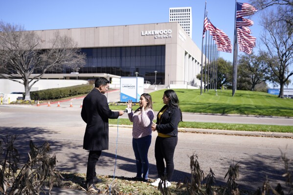 Andrea Espinoza, center, and Nicole Guevara are interviewed by Telemundo reporter Mitchell Zavallos on Monday, Feb. 12, 2024, in Houston, about their experiences during the shooting inside Lakewood Church in Houston. A shooting at the church in left a woman dead and a child critically wounded. (Karen Warren/Houston Chronicle via AP)