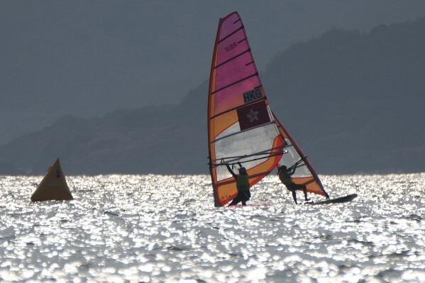 Thailand's Siripon Kaewduang-Ngam, right, and Ngai Wai Yan of Hong Kong, left, compete in the women's RS:X class final race at Ningbo Xiangshan Sailing Center at the 19th Asian Games in Ningbo, China, Tuesday, Sept. 26, 2023. (AP Photo/Eugene Hoshiko)