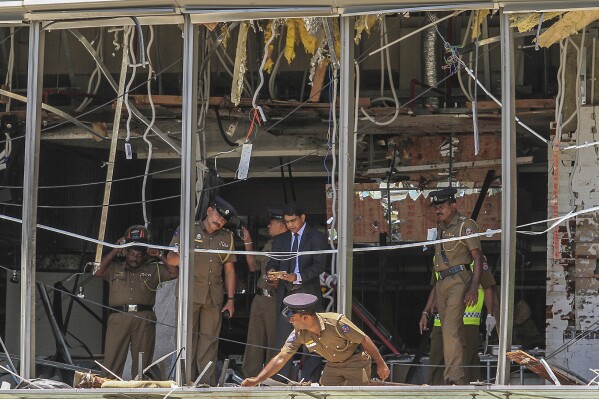 FILE- In this April 21, 2019, file photo, Sri Lankan police officers inspect the site of an explosion at the Shangri-la hotel in Colombo, Sri Lanka. Sri Lanka’s government will appoint a parliamentary committee to investigate allegations made in a British television report that Sri Lankan intelligence had complicity in the 2019 Easter Sunday bombings that killed 269 people. (AP Photo/Chamila Karunarathne, file)