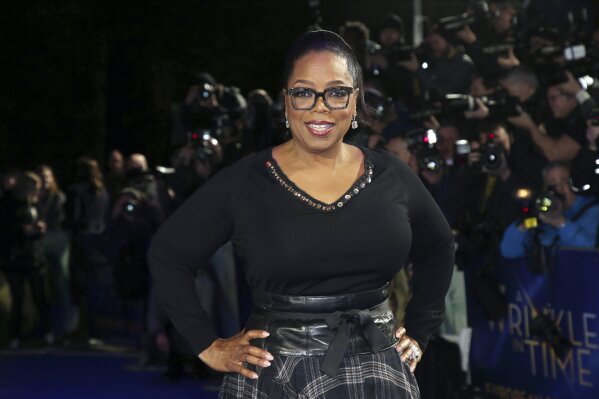 FILE - In this March 13, 2018, file photo, actress Oprah Winfrey poses for photographers upon arrival at the premiere of the film "A Wrinkle In Time" in London. Winfrey said Friday, Jan. 17, 2020, that Russell Simmons attempted to pressure her about her involvement with the documentary, “On the Record," in which several women detail sexual abuse allegations against the rap mogul, but his efforts were not what prompted her to leave the project. (Photo by Joel C Ryan/Invision/AP, File)