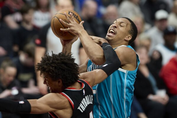 Charlotte Hornets forward Grant Williams, right, is fouled by Portland Trail Blazers guard Matisse Thybulle during the second half of an NBA basketball game in Portland, Ore., Sunday, Feb. 25, 2024. (AP Photo/Craig Mitchelldyer)