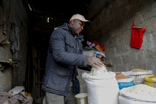 Vendor Francis Ndege measures rice at his stall in the Toi Market, Nairobi, Kenya on Wednesday, Aug. 9, 2023. Countries worldwide are scrambling to secure rice after a partial ban on exports by India cut global supplies by roughly a fifth. Now, Ndege isn’t sure if his customers in Africa’s largest slum can afford to keep buying rice from him. (AP Photo/Brian Inganga)