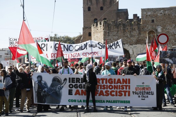 Palestinian supporters hold a banner reading "Yesterday partisans, today antiZionists and antifascists" as they march on the occasion of the Liberation Day commemoration marking Italy's liberation from Nazi occupation and fascist rule, in Rome, Thursday, April 25, 2024. (Cecilia Fabiano/LaPresse via AP)